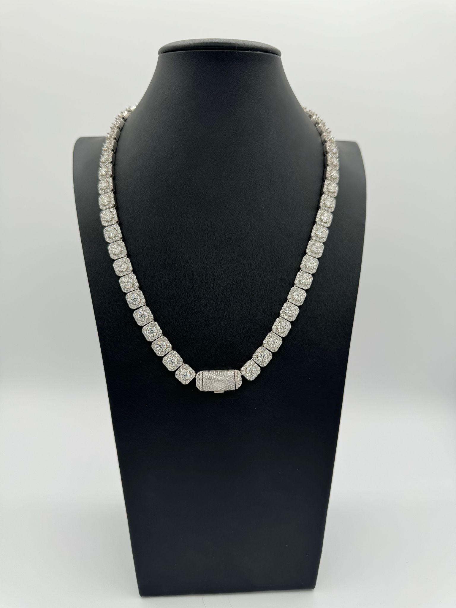 A necklace is on a mannequin with a white background