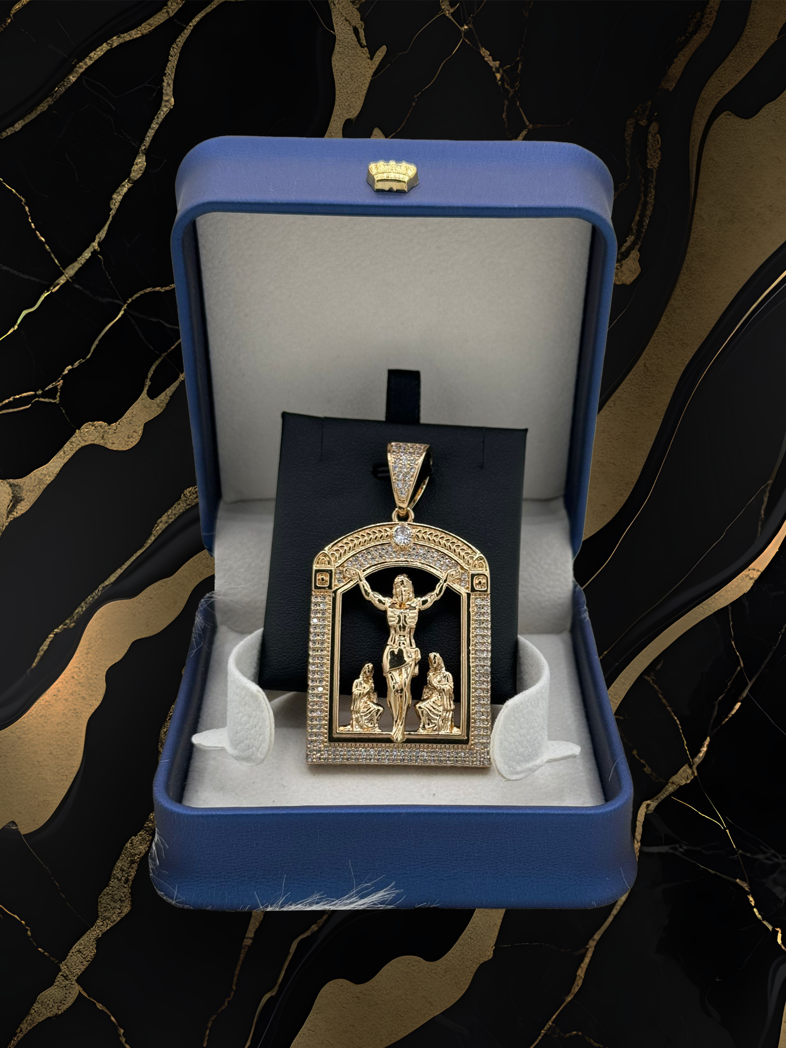 A gold pendant with jesus on the cross is in a blue box.