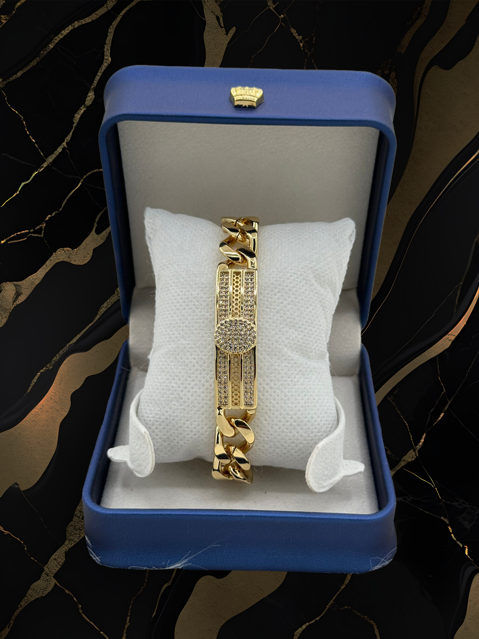 A gold bracelet is in a blue box on a pillow.