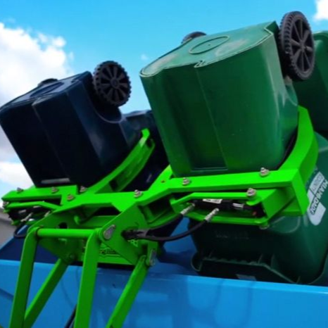 A green trash can with a piece of paper in it.