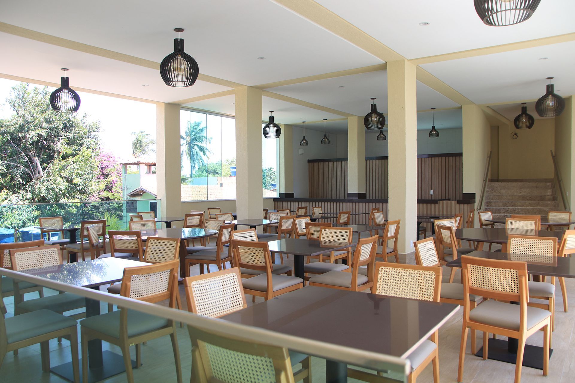 Uma grande sala com mesas e cadeiras em um restaurante