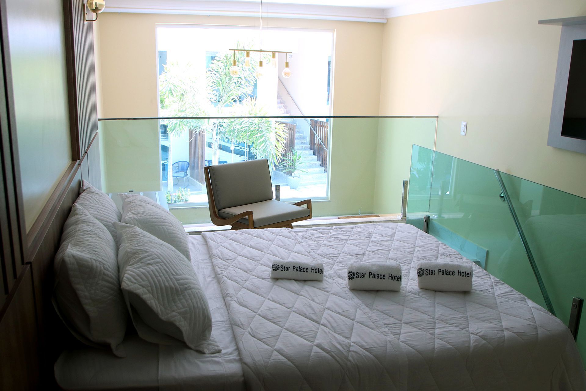 Um quarto com uma cama king size e uma cadeira