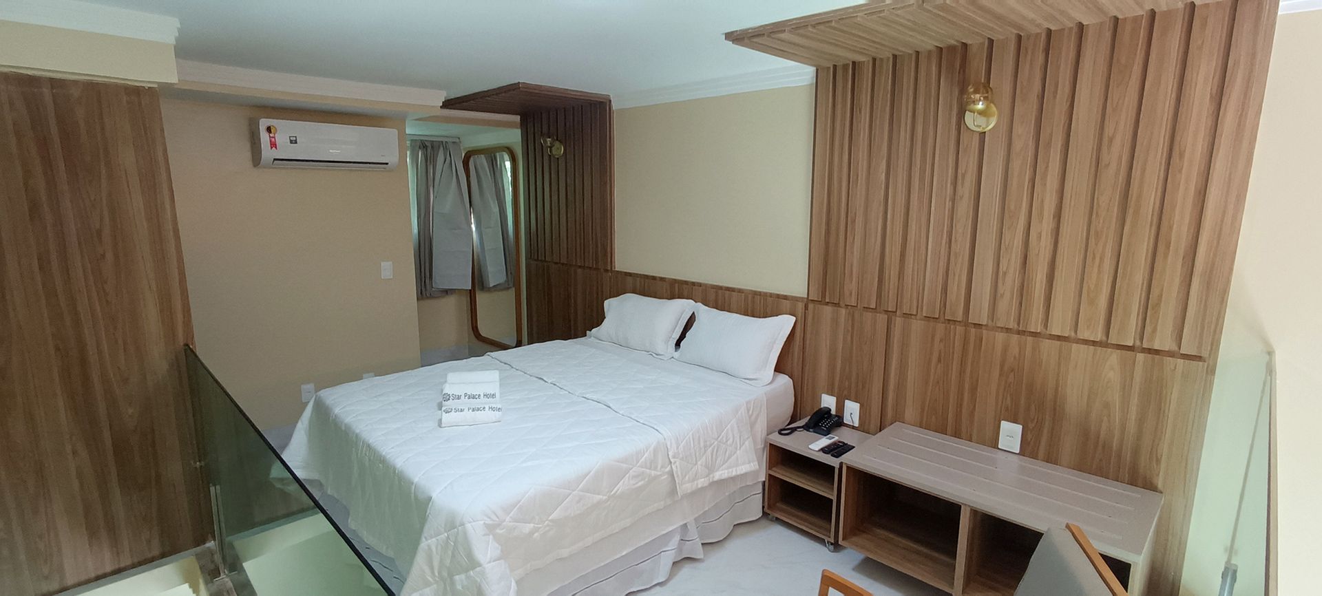 Um quarto de hotel com cama king size e escada.