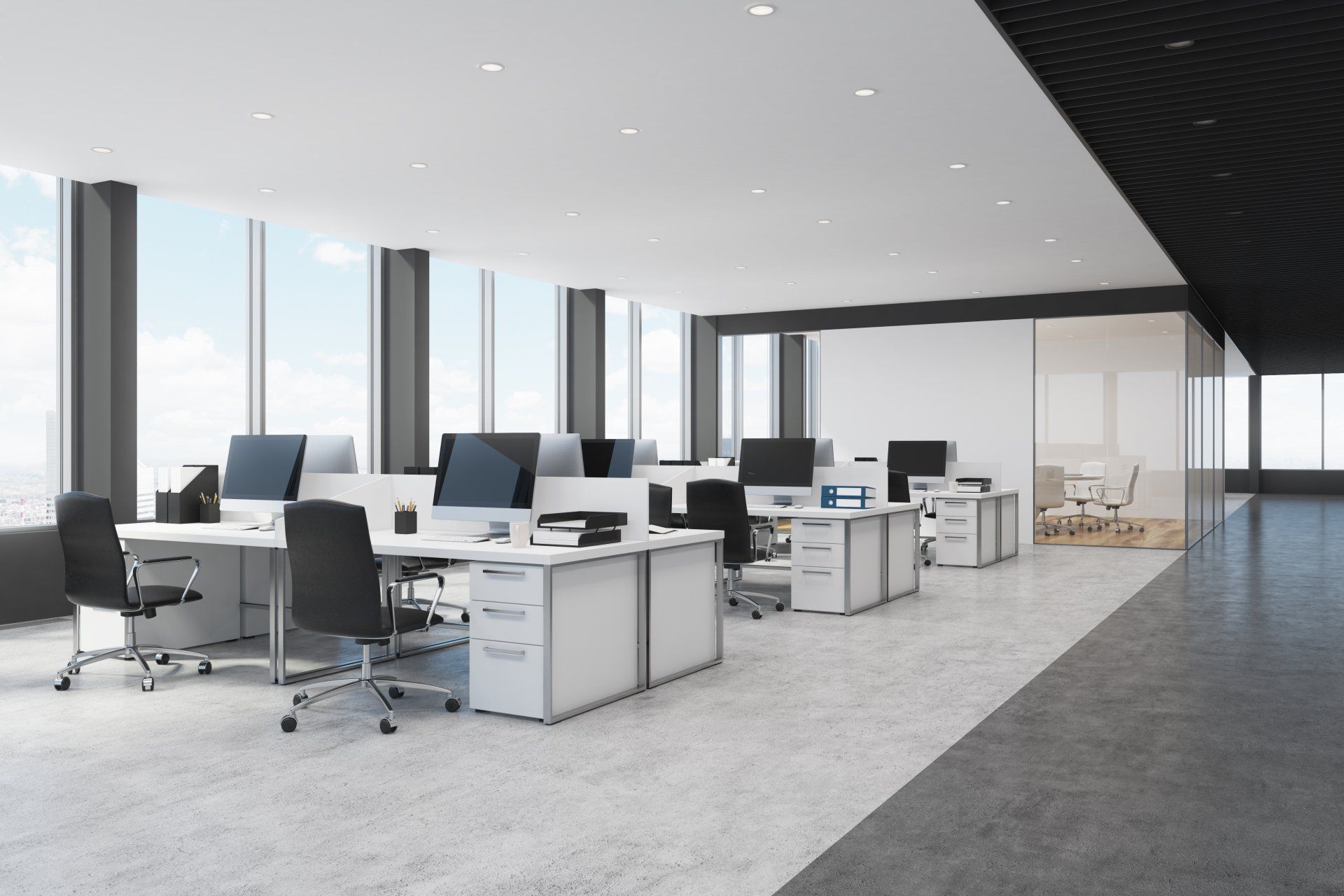 white and black open space office interior with rows of computer tables with desktops standing on them.