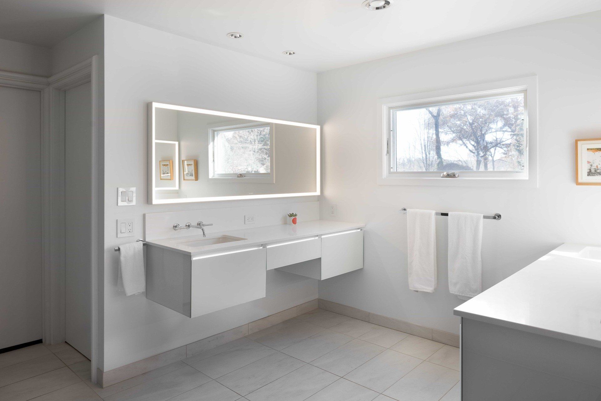 Modern bathroom with large backlit mirror