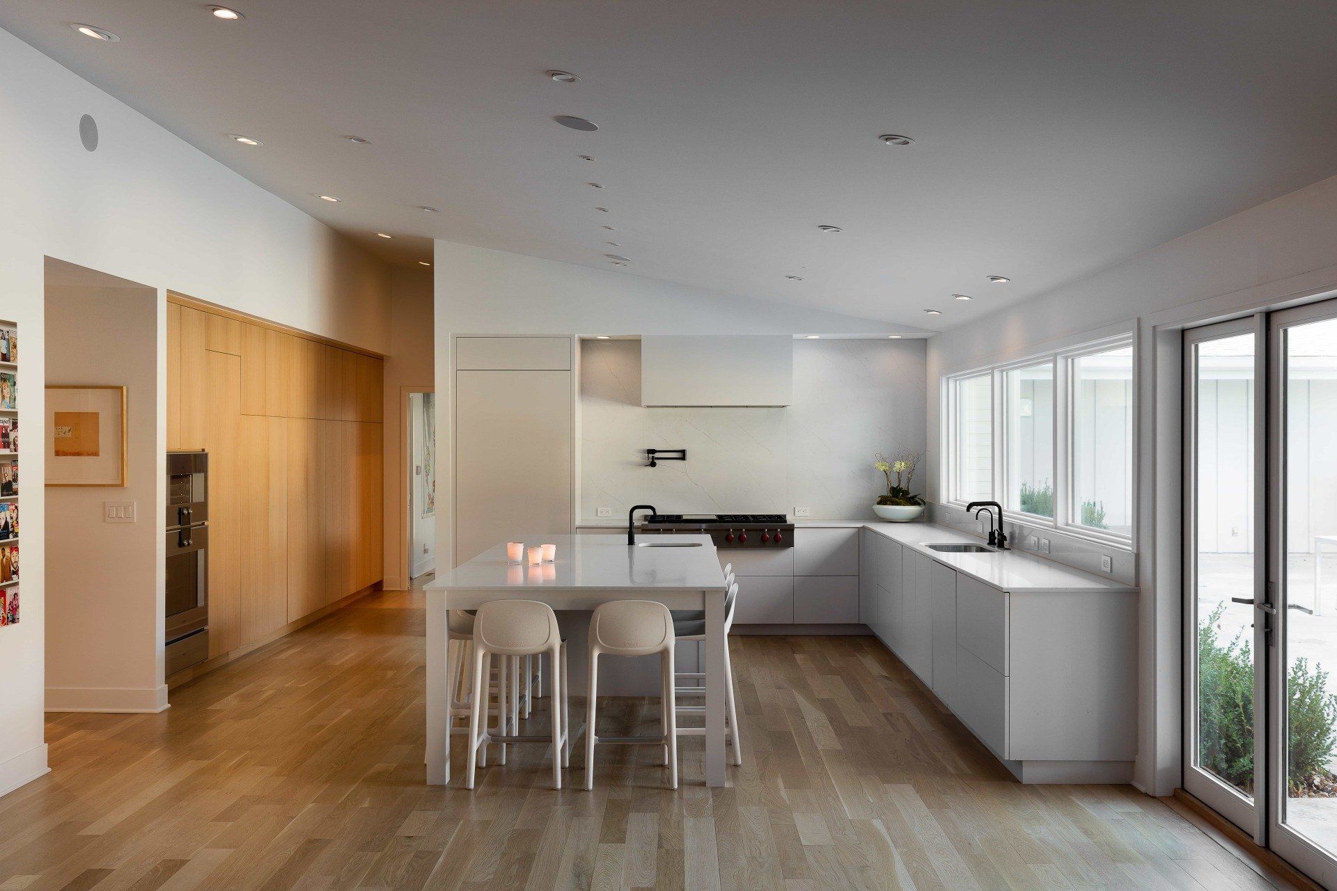 Modern kitchen with white cabinetry, large island, and abundant natural light