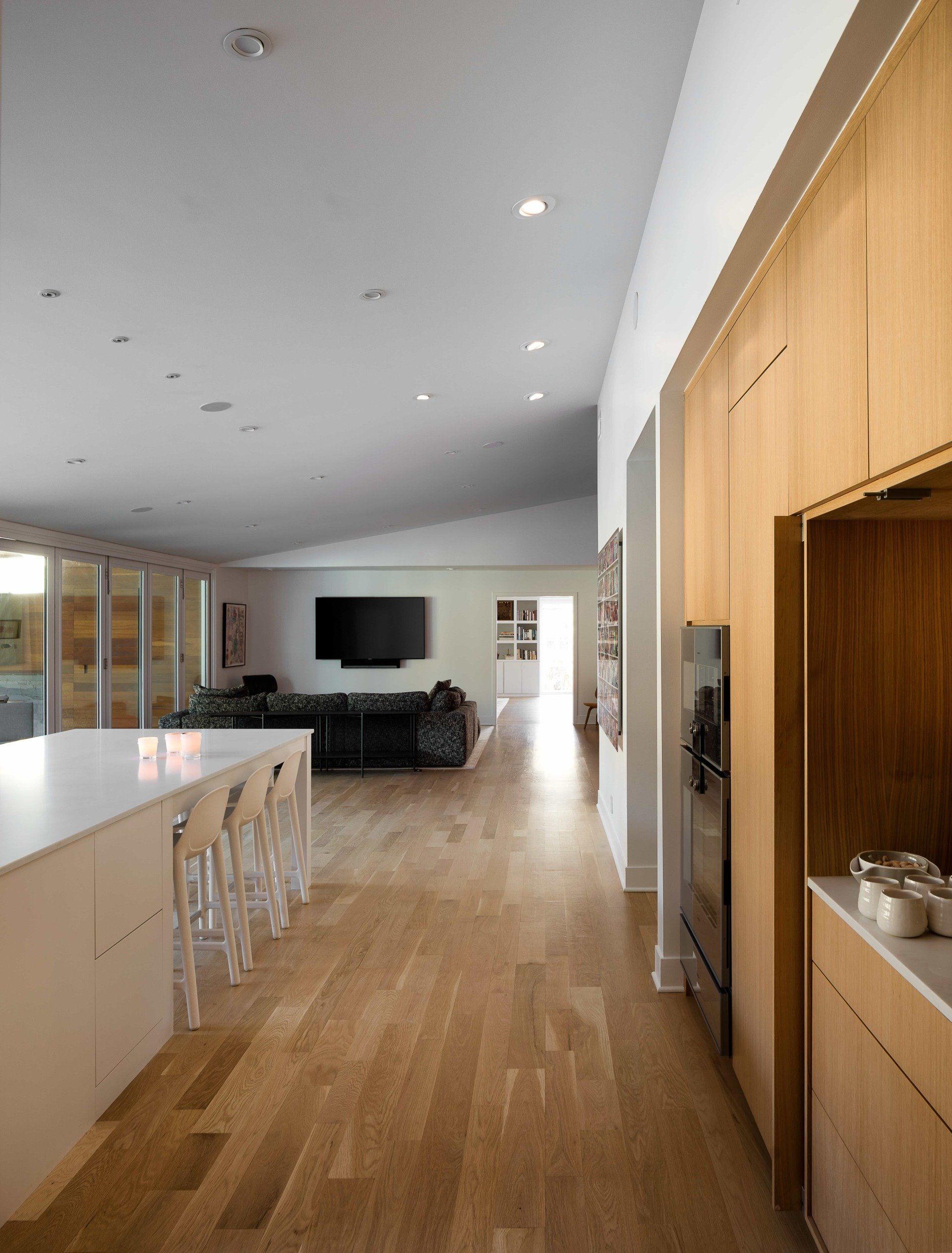 Modern kitchen with large white island and view of living room