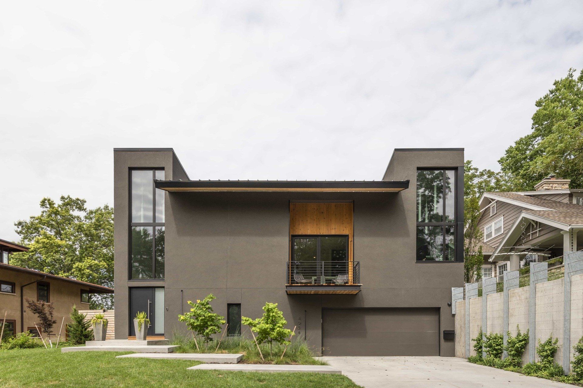 Straight on view of a modern, grey, high performance home with large windows