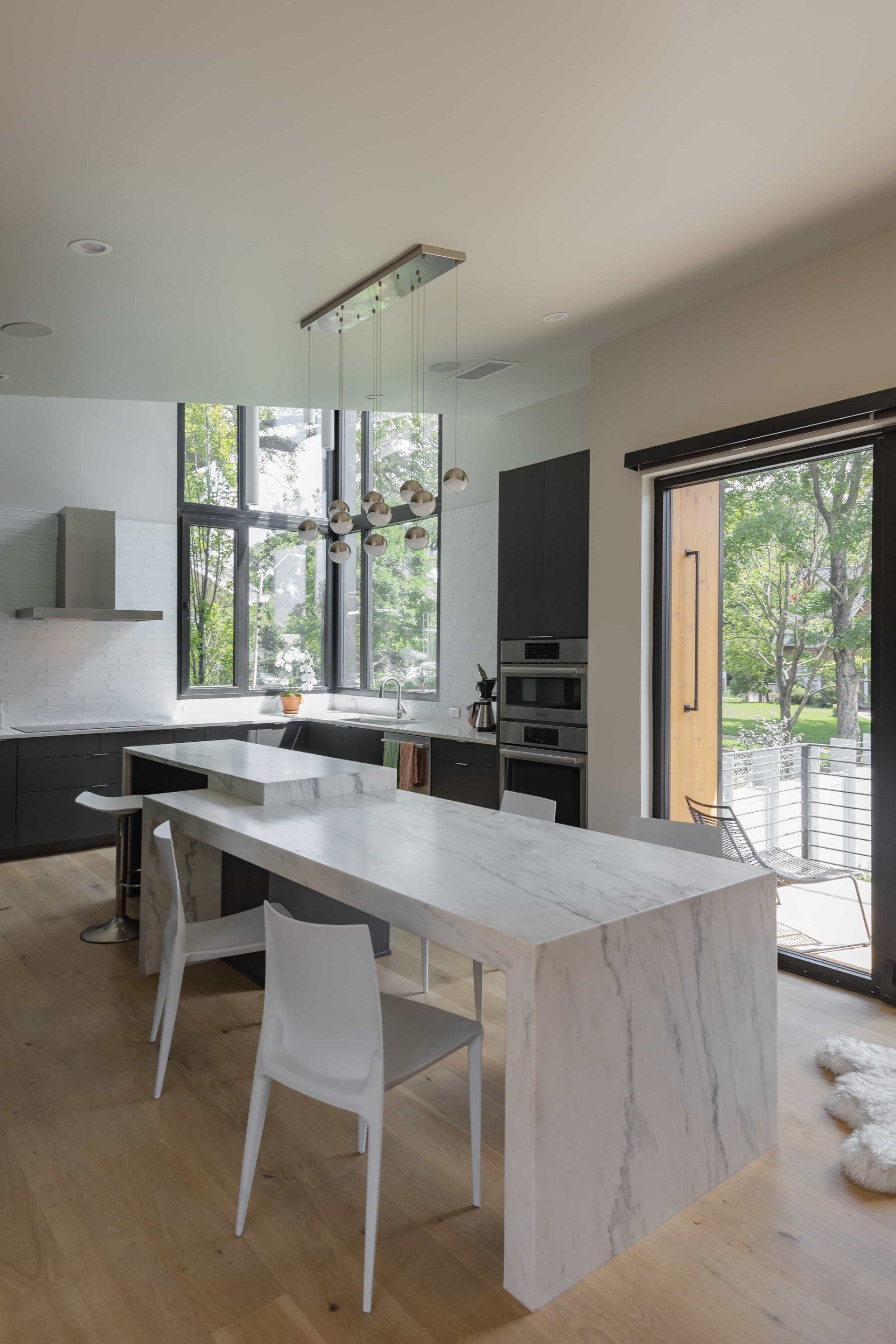 Side view of stone kitchen island in a modern kitchen with a sliding glass door letting lots of natural light in