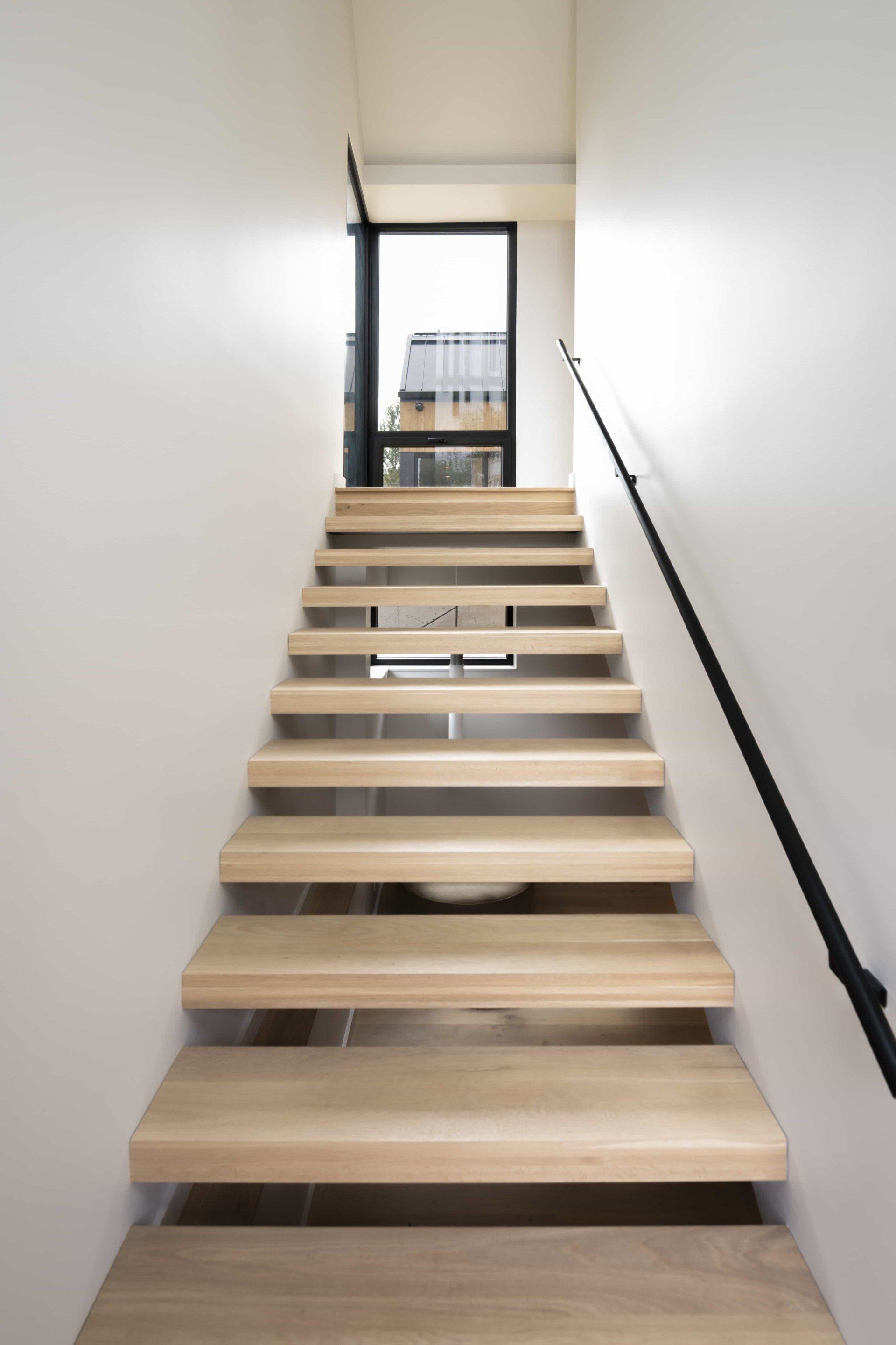 Modern staircase with light wood and white walls