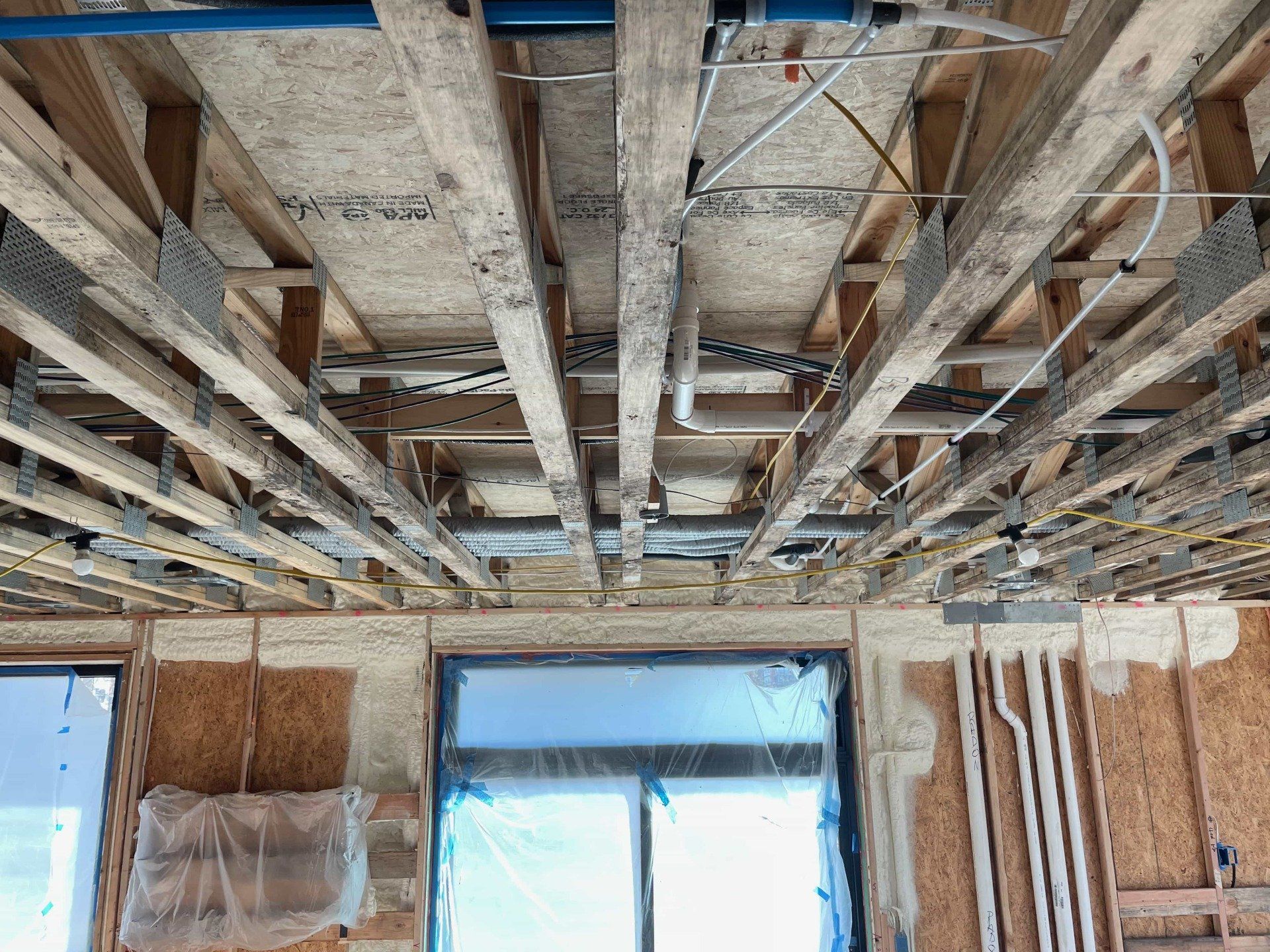 Closed cell spray foam insulation shown on the first floor of a home under construction