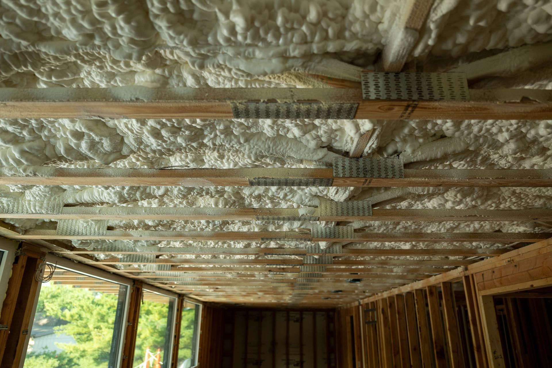Blown in insulation shown from above throughout open web trusses