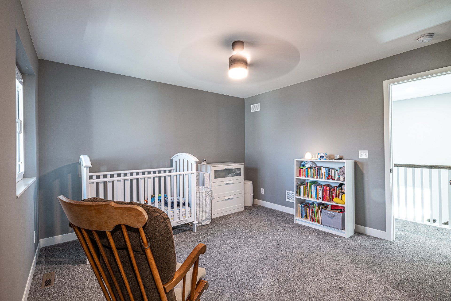 Child's bedroom with white crib and rocking chair.