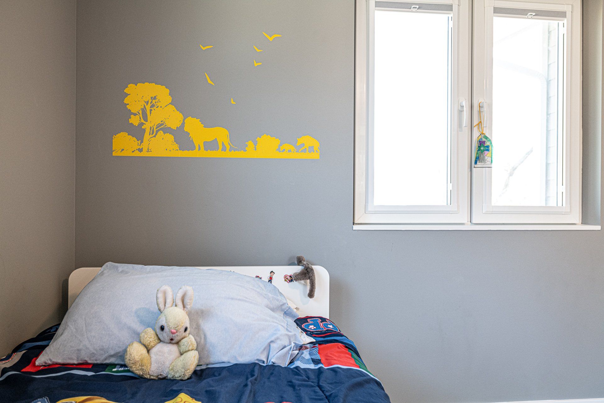 Toddler bed with wall graphic showing animals in the jungle.