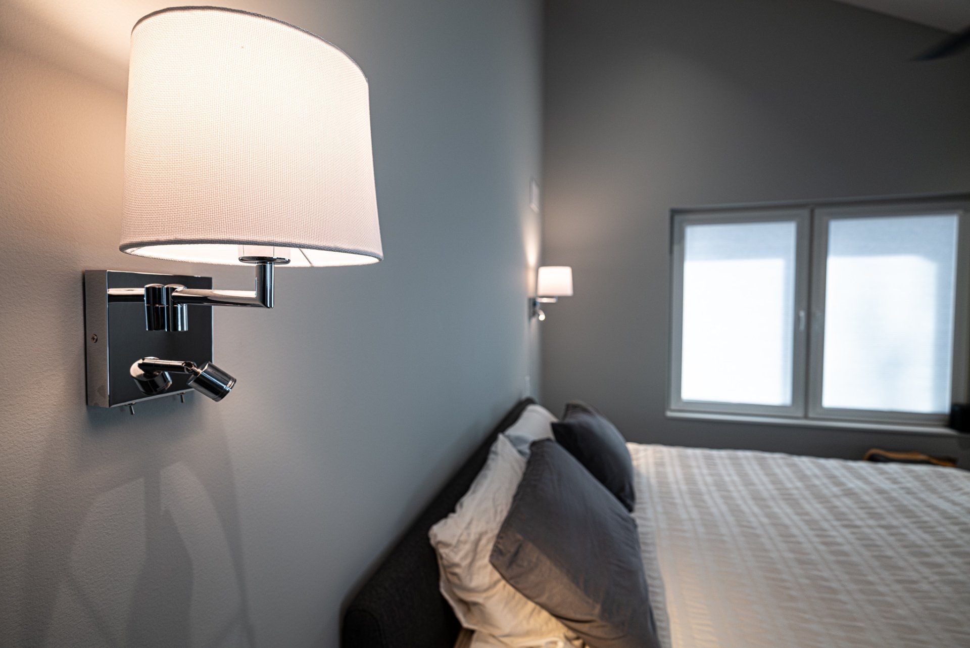Primary bedroom with king size bed and wall lighting.