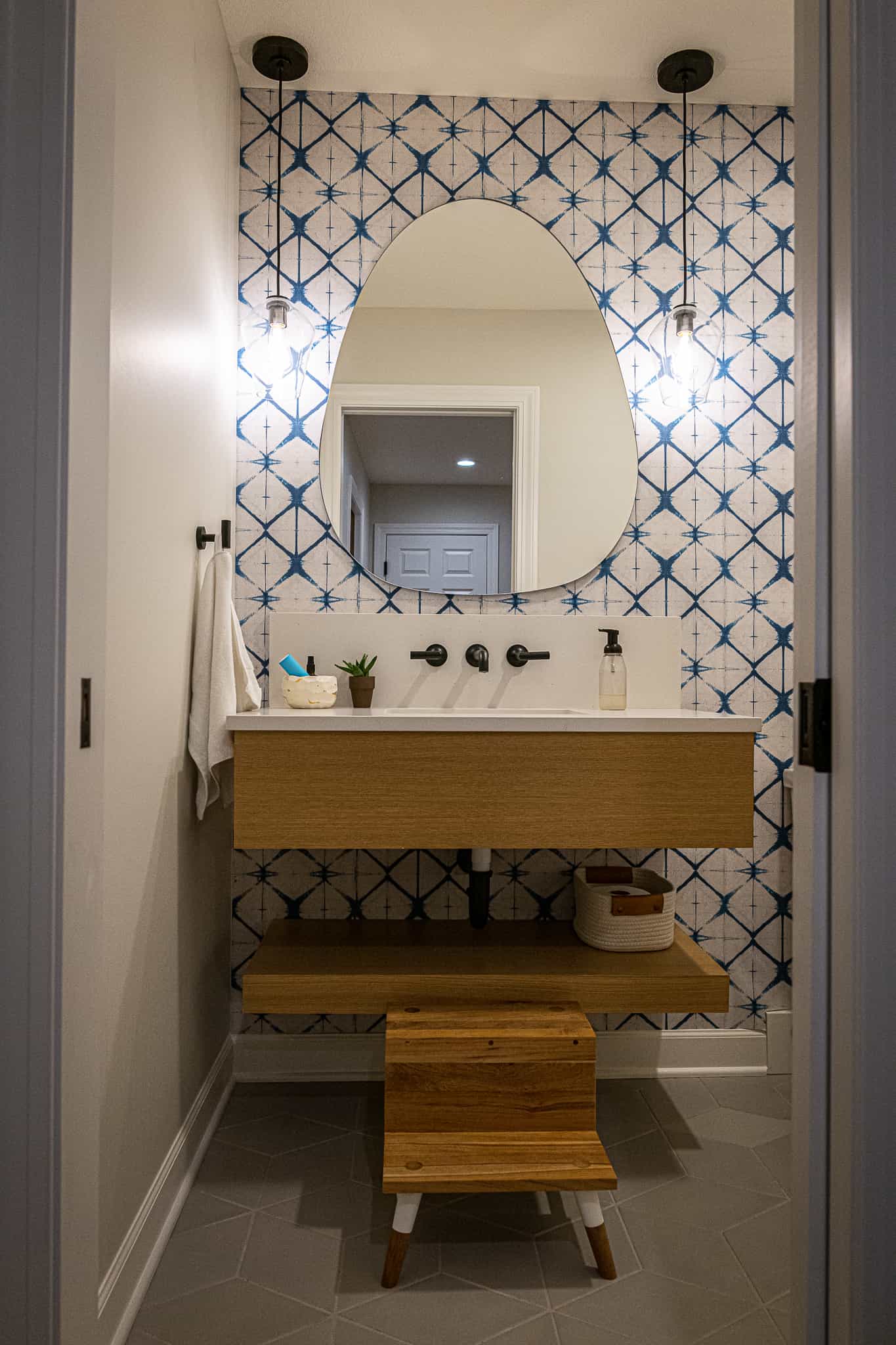 Powder room with fun backsplash and modern mirror