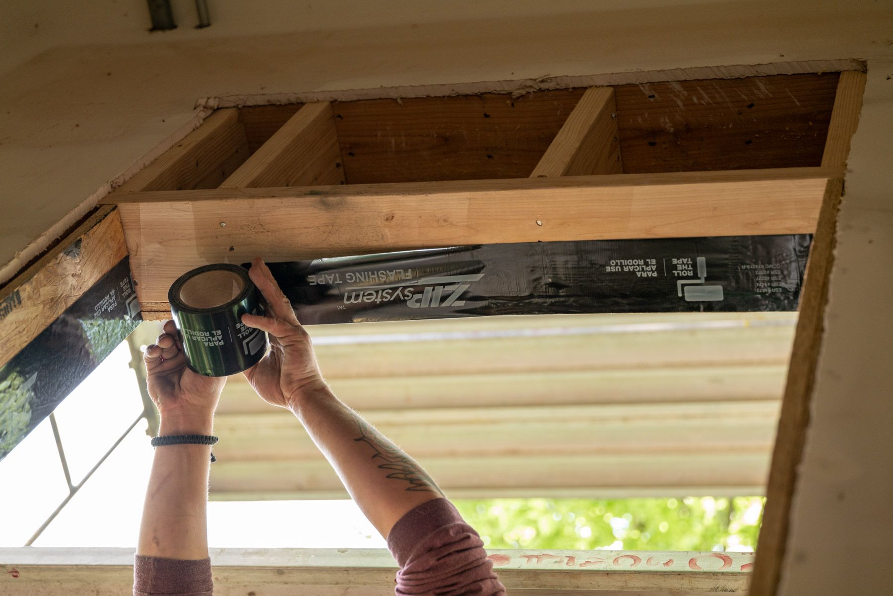 Air sealing a window replacement by rolling zip tape onto a window opening