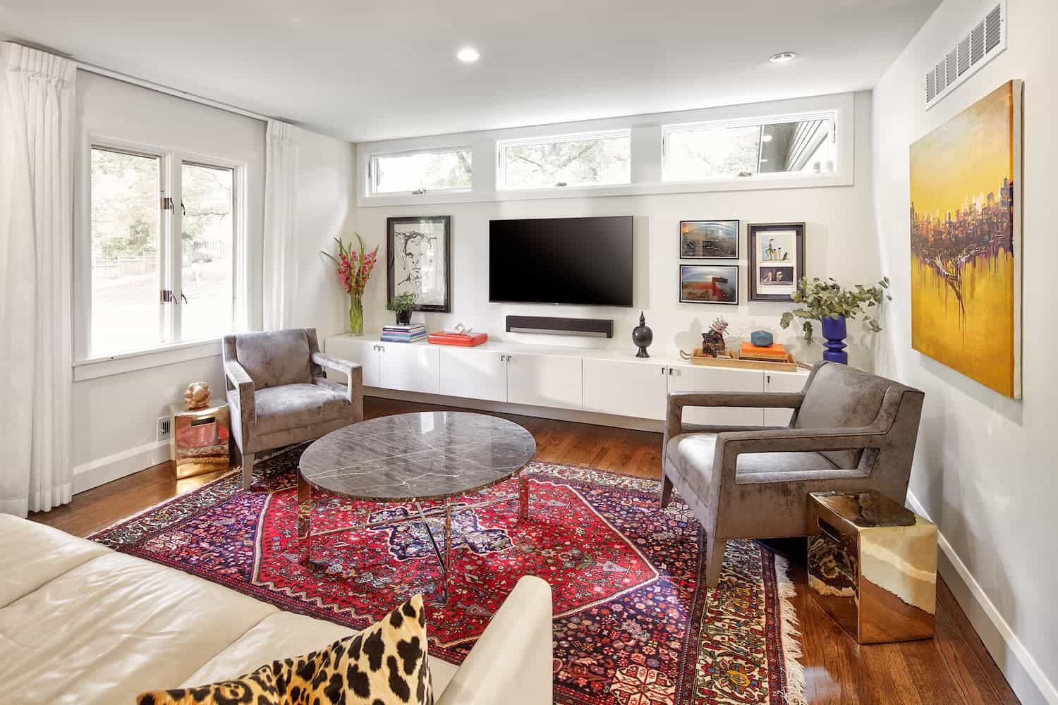 Bright, modern, eclectic living room with red area rug