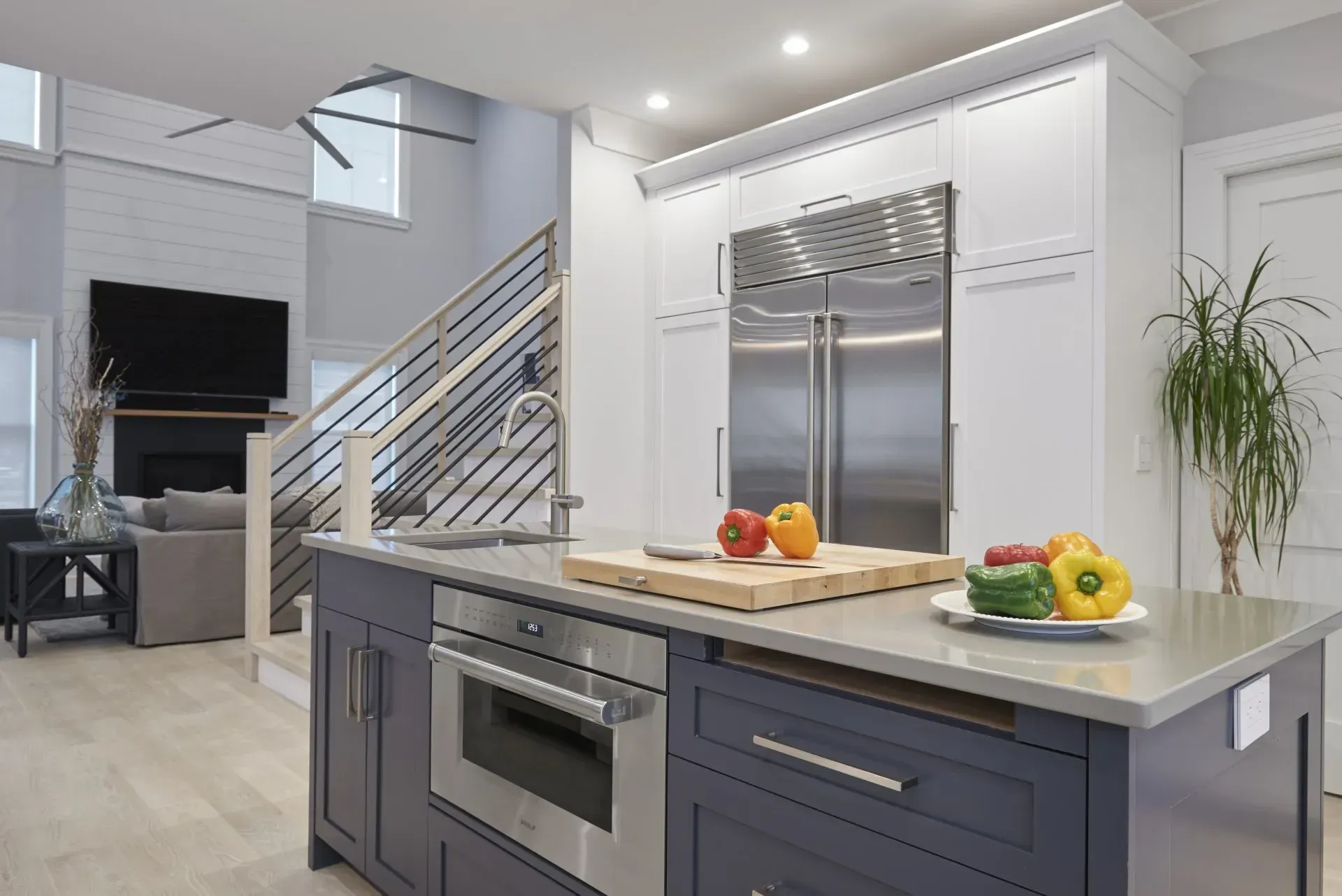 Modern kitchen with island, stainless steel appliances, and fresh produce.