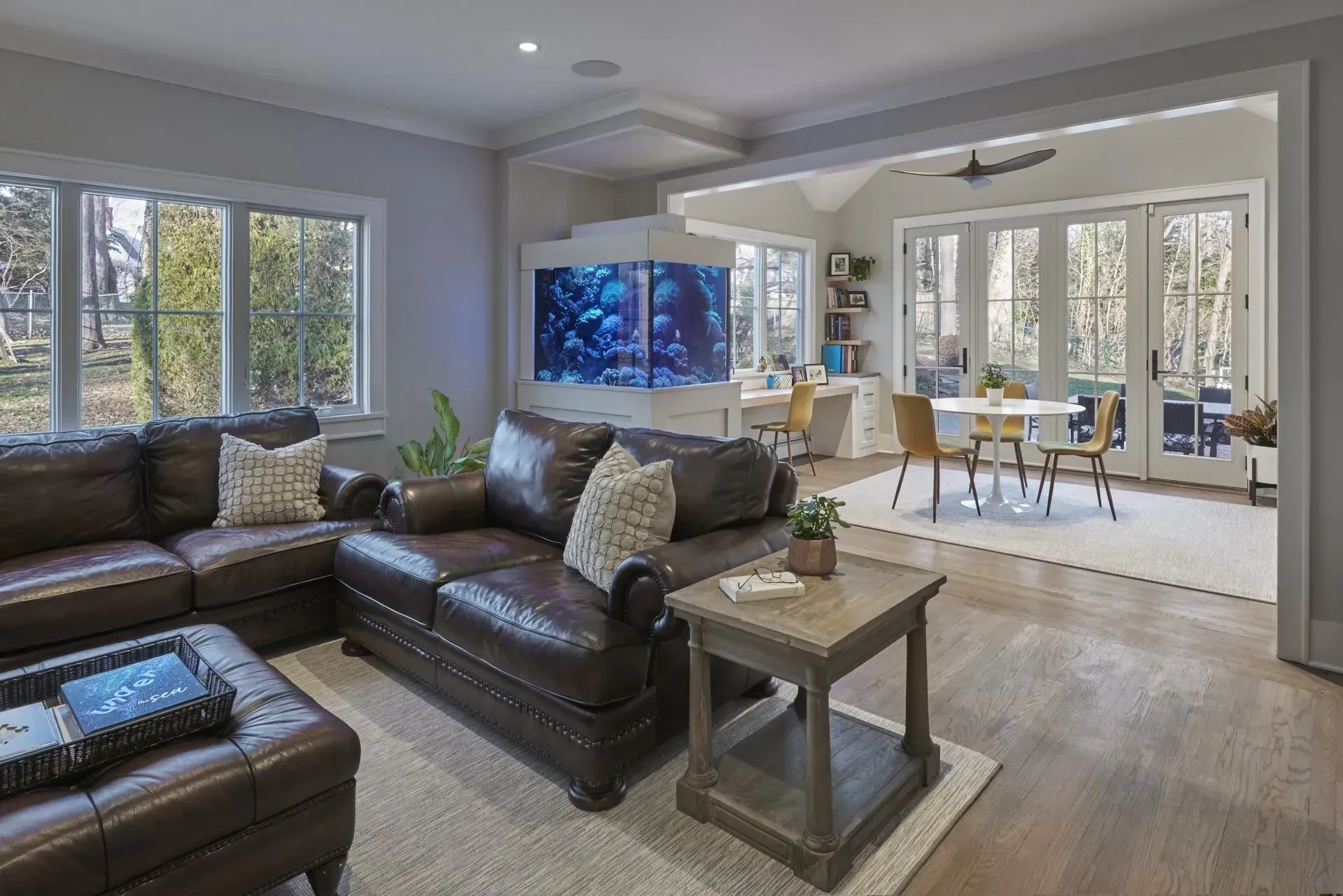 Living room with brown leather sectional sofa, large aquarium, and dining area.