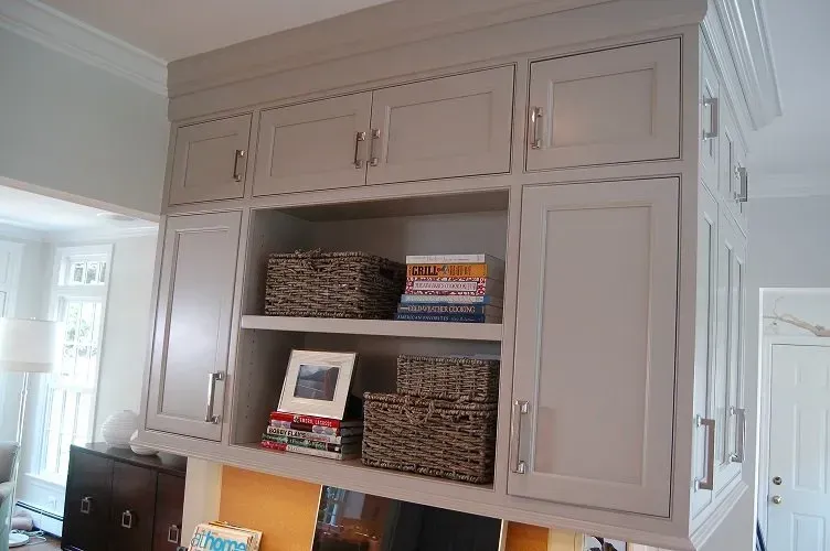 Gray built-in cabinets with open shelving and wicker baskets.