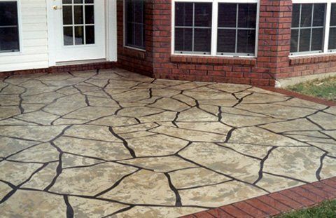 A Brick House With A Stone Patio In Front Of It - Monroe, LA - Decorative Concrete Coatings LLC