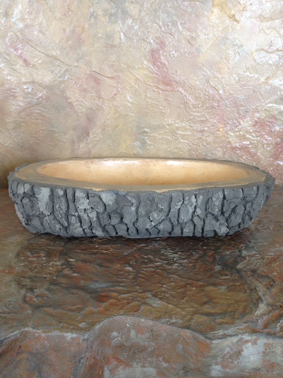 A wooden bowl is sitting on top of a rock on a table.
