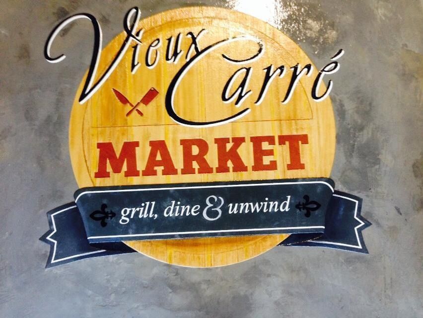 A sign for vieux carre market grill dine and unwind