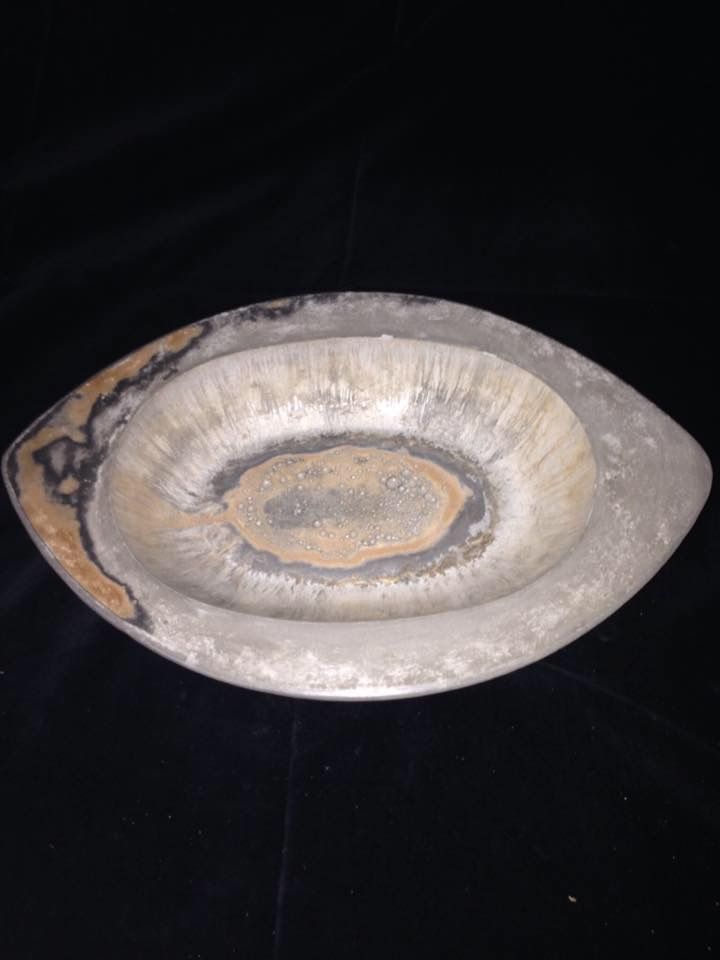 A close up of a bowl on a black surface.