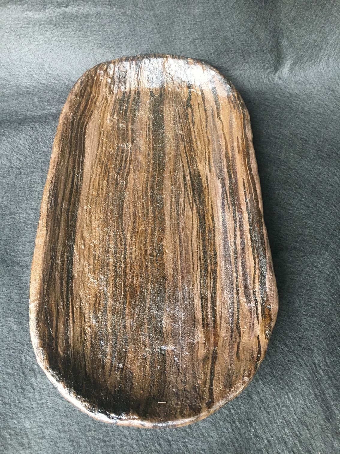 A wooden tray is sitting on a black surface.