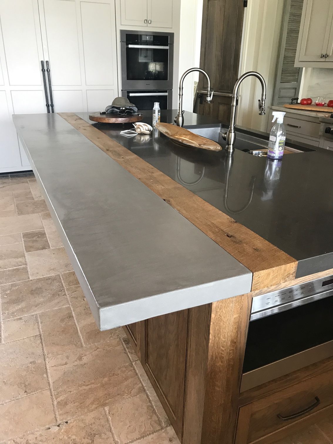 A kitchen with a stainless steel counter top and a wooden counter top.