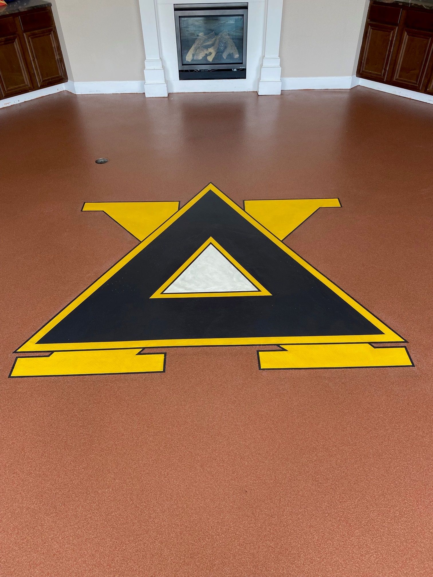 A black and yellow triangle with the letter a painted on the floor.