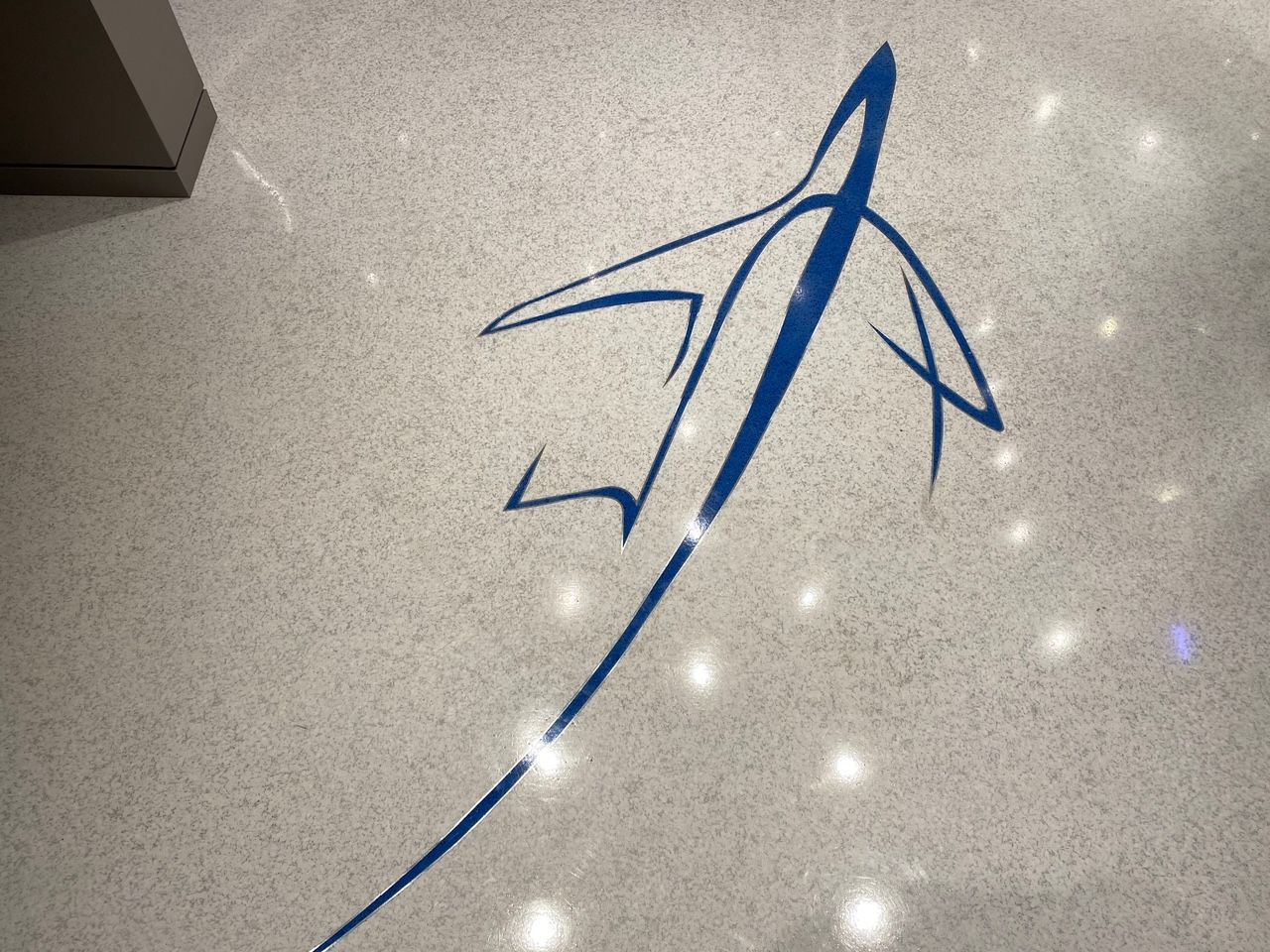A blue drawing of an airplane on a white floor