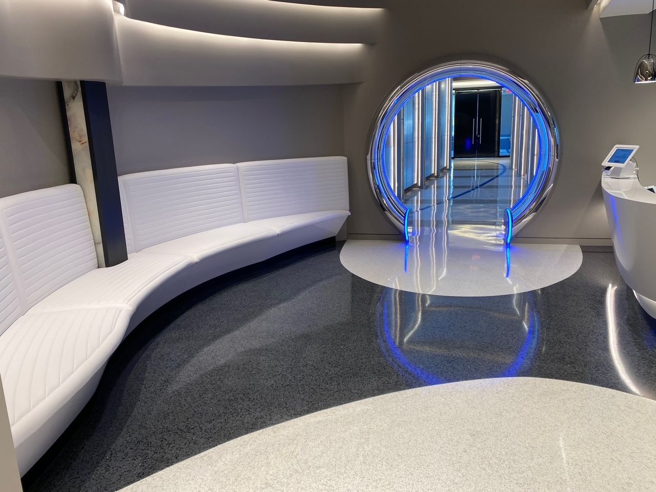 A room with a round window and a white bench