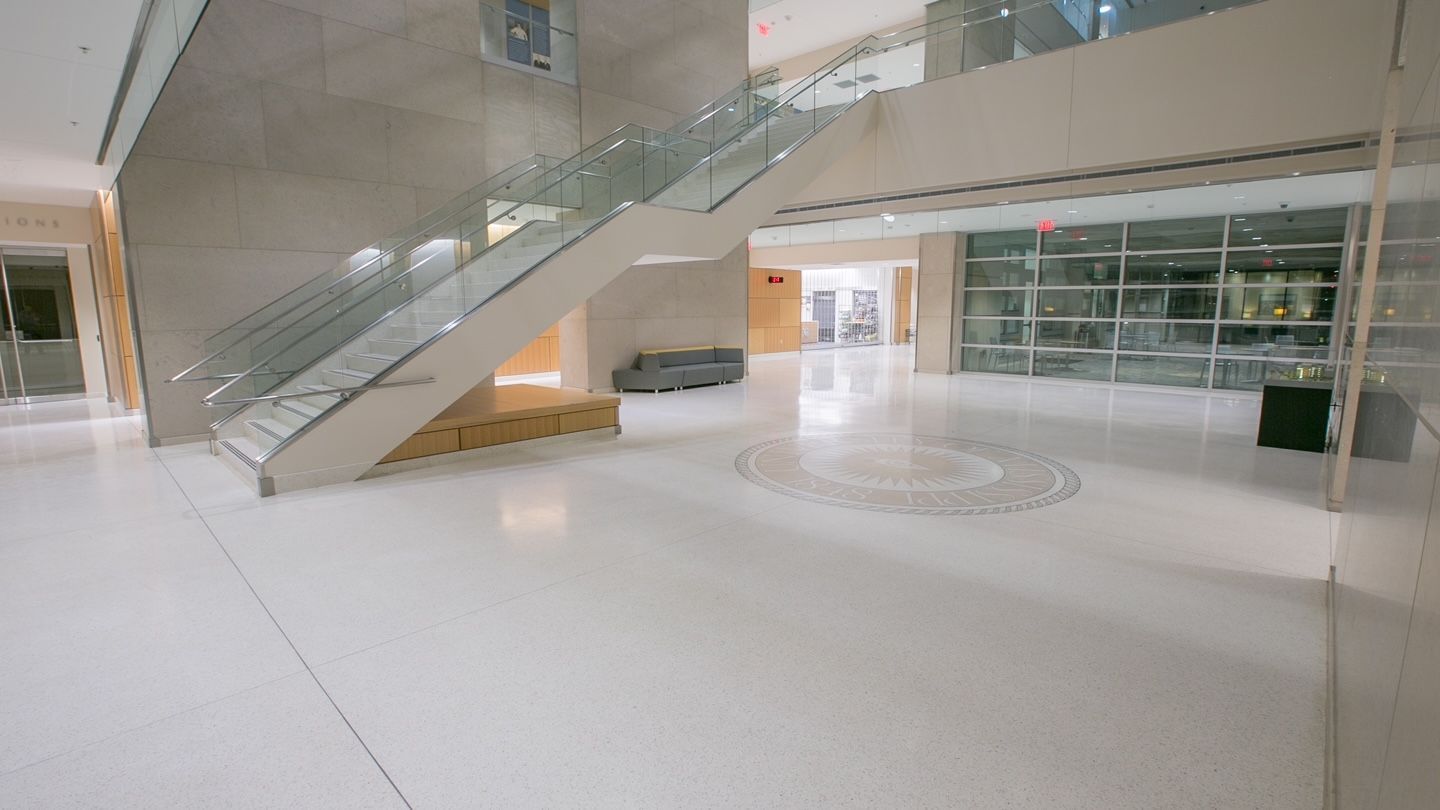 A large empty lobby with stairs in a building.