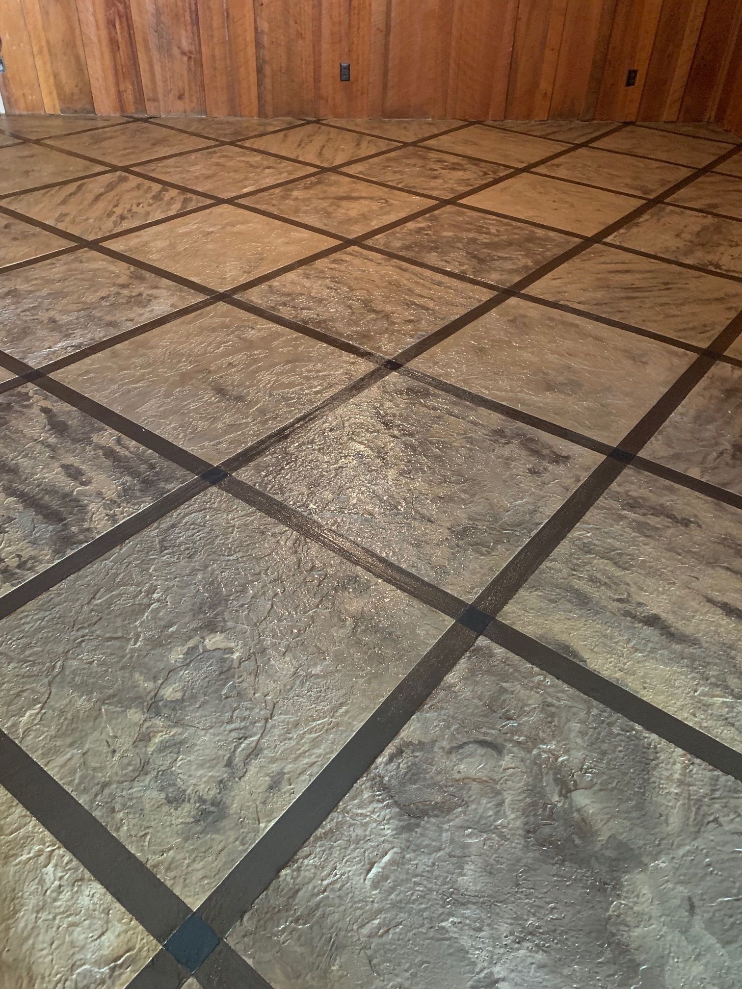 A close up of a tiled floor in a room with wood paneling.