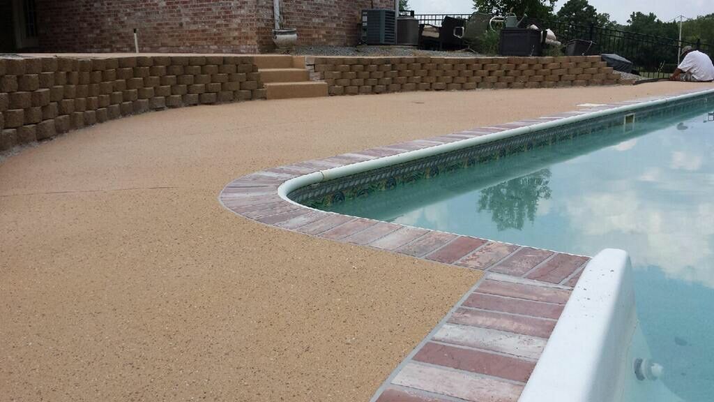 A swimming pool with a brick border and a brick wall surrounding it.