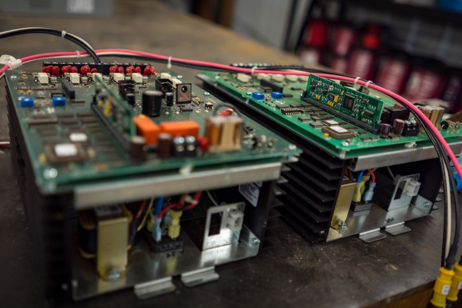 Two electronic boards are sitting on top of each other on a table.