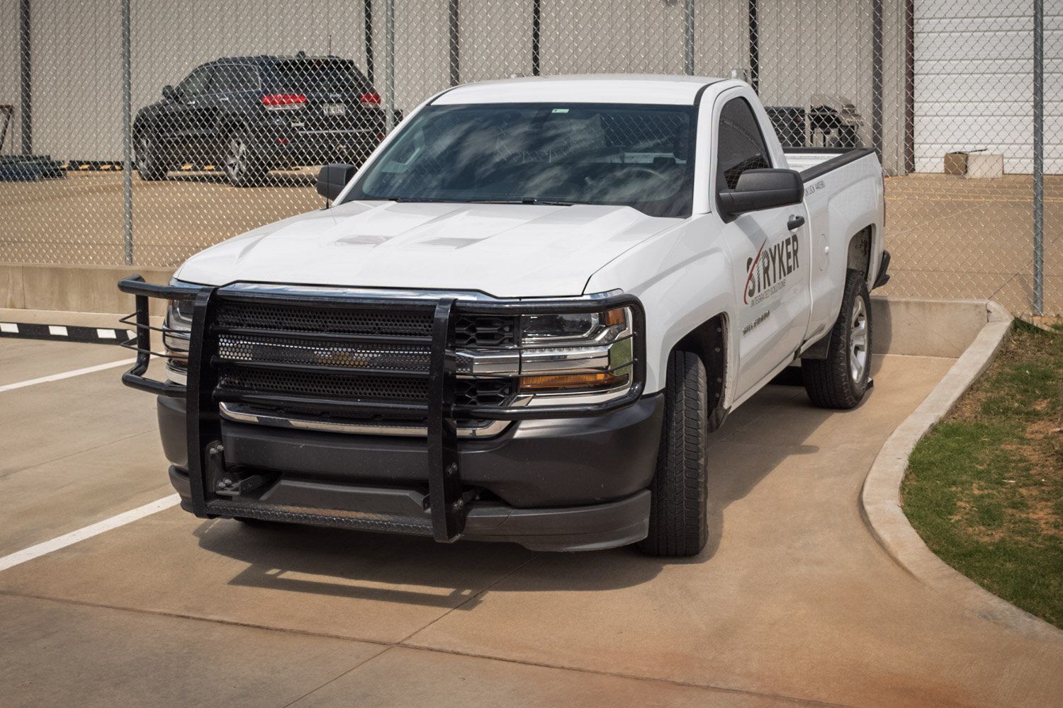 A white truck with the word sheriff on the side is parked in a parking lot.