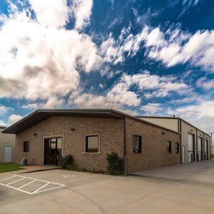 A large brick building with a parking lot in front of it.