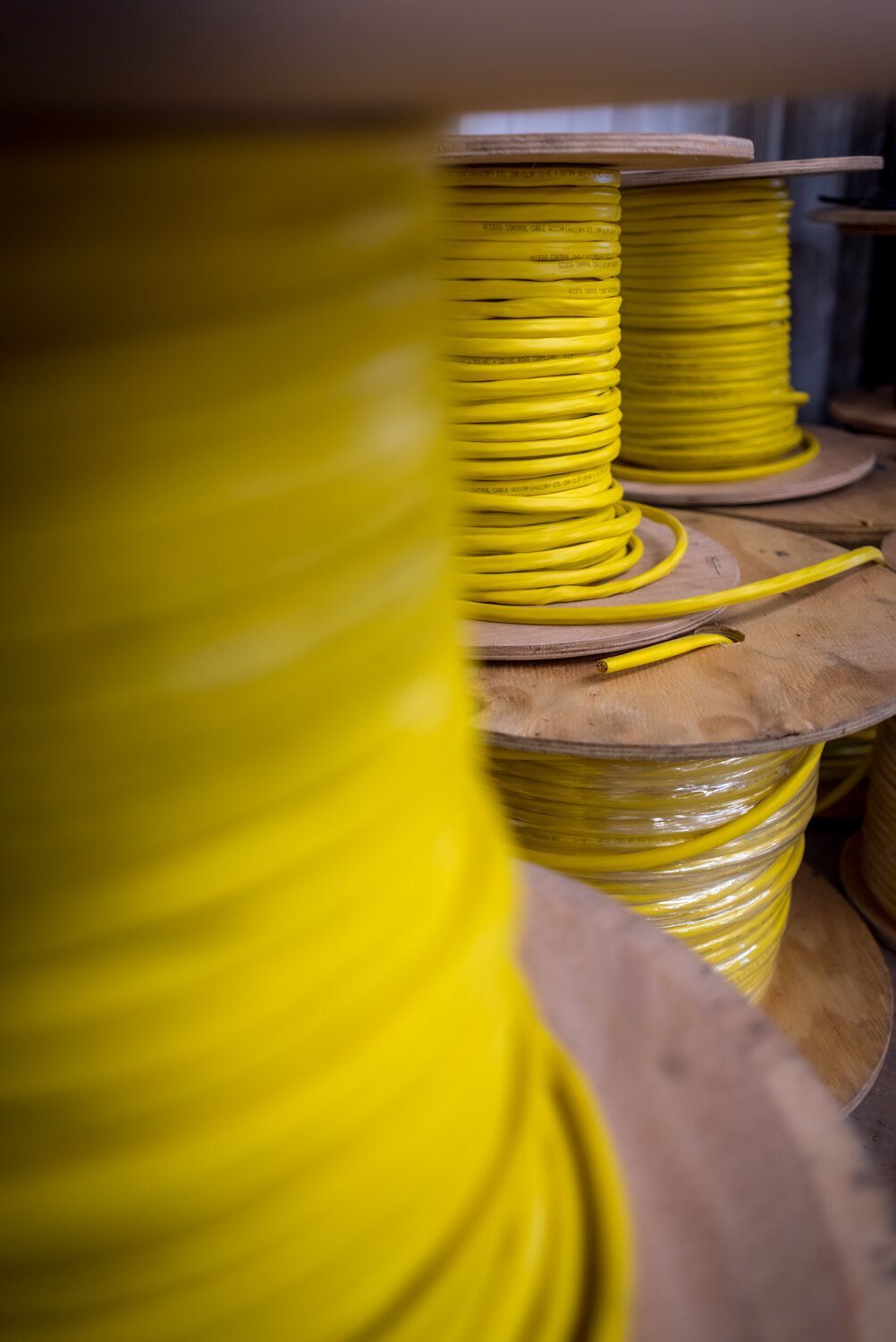 A bunch of spools of yellow wire are stacked on top of each other.