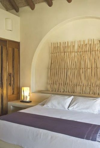 Un dormitorio con una cama grande y una manta morada.