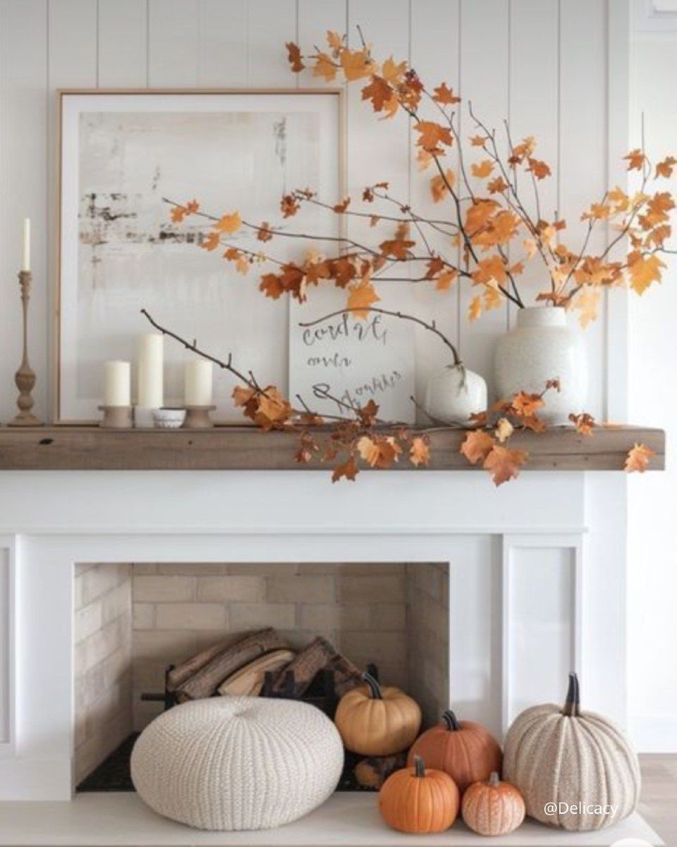 Manteau décoré pour l'automne avec des citrouilles, des feuilles, des bougies et un vase blanc.