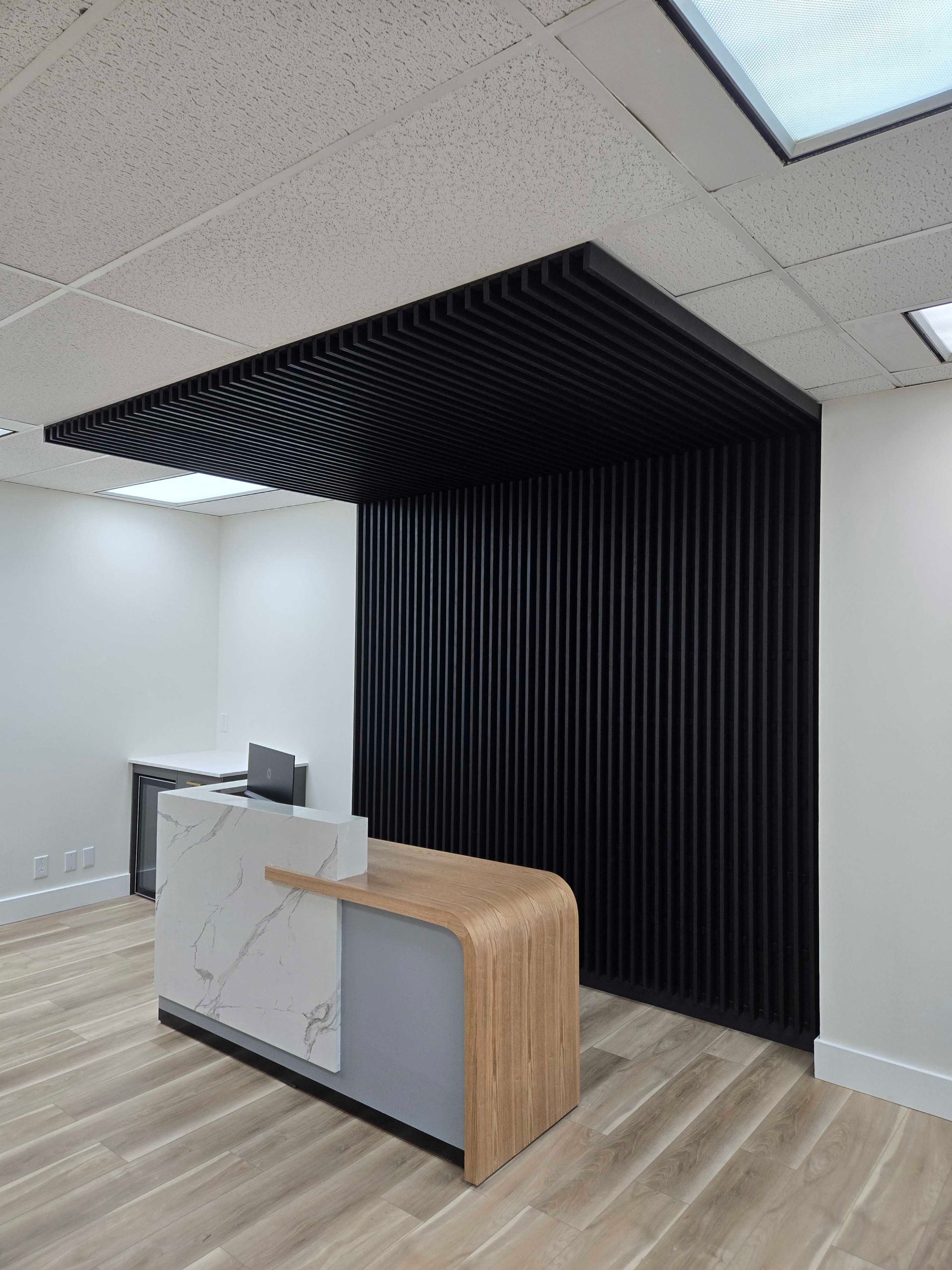 Mur à lattes de bois avec un banc intégré, des tons neutres, un sac et une plante en pot.