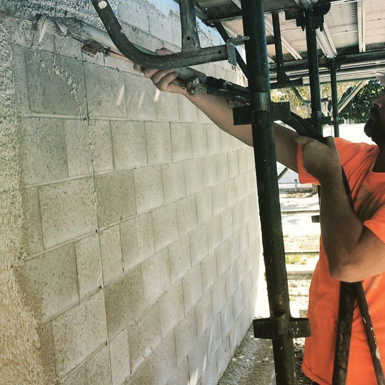 Worker cementing wall — About Rock Solid Rendering in Brisbane, QLD