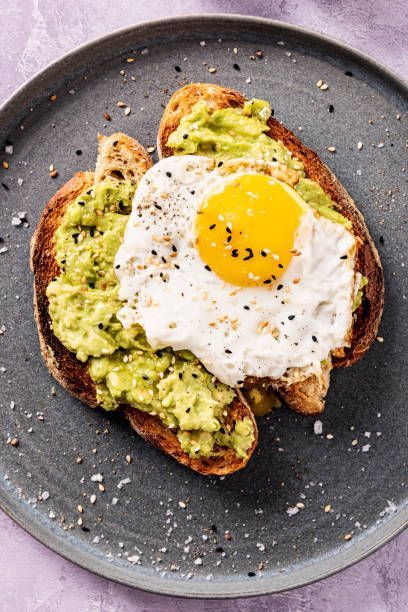 A plate of avocado toast with a fried egg on top.