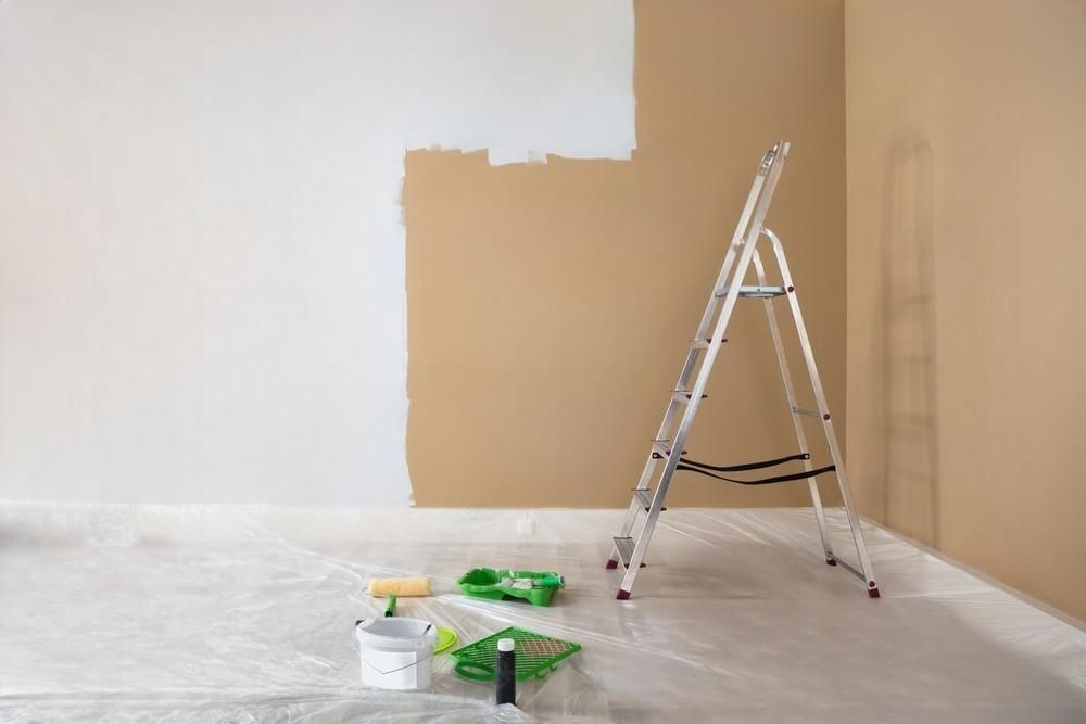 a room is being painted with a ladder and paint supplies .