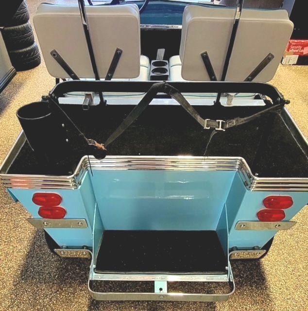 The back of a blue golf cart with two seats