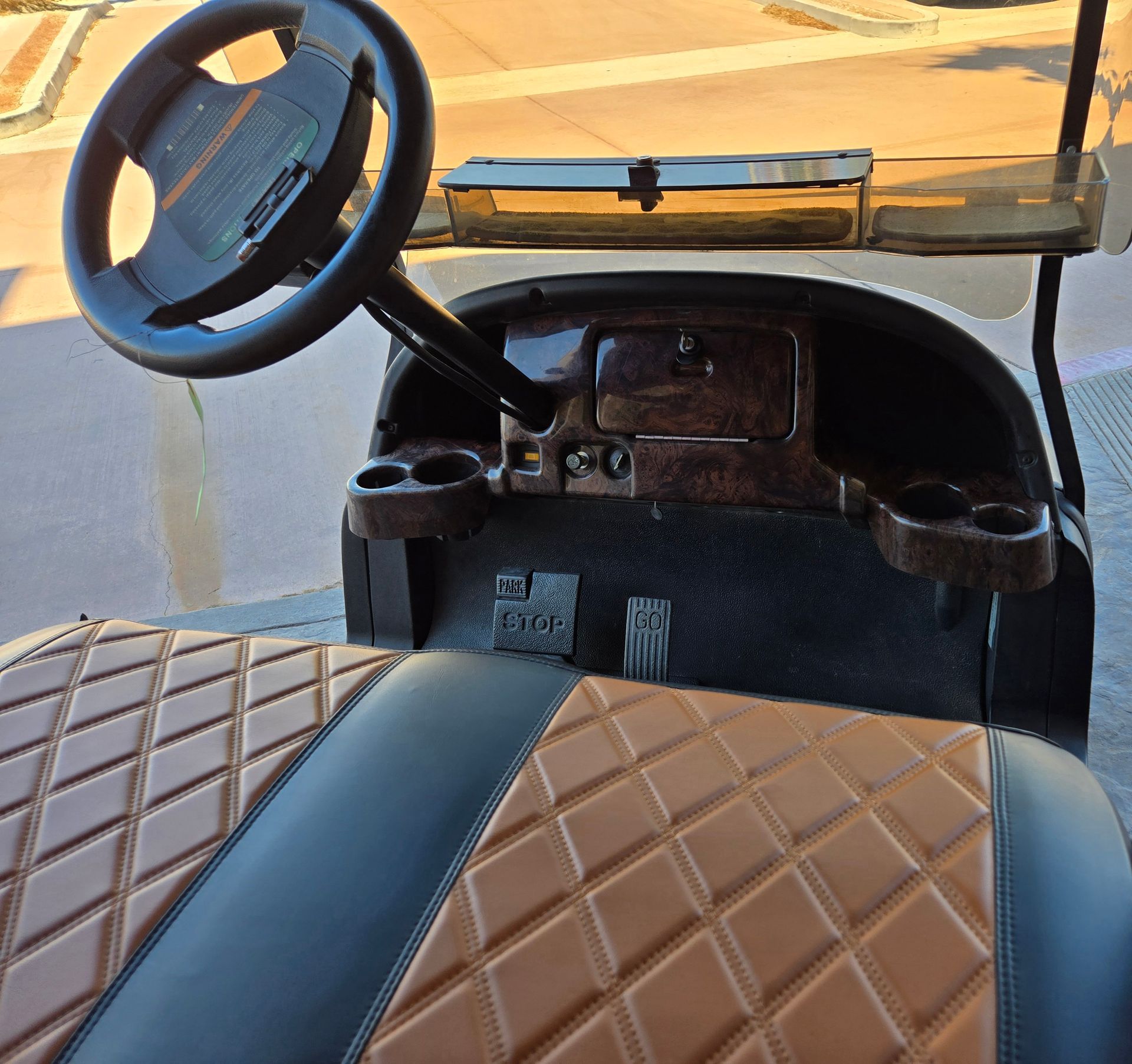 The inside of a golf cart with a steering wheel