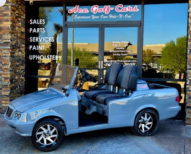 A golf cart is parked in front of ace golf cars